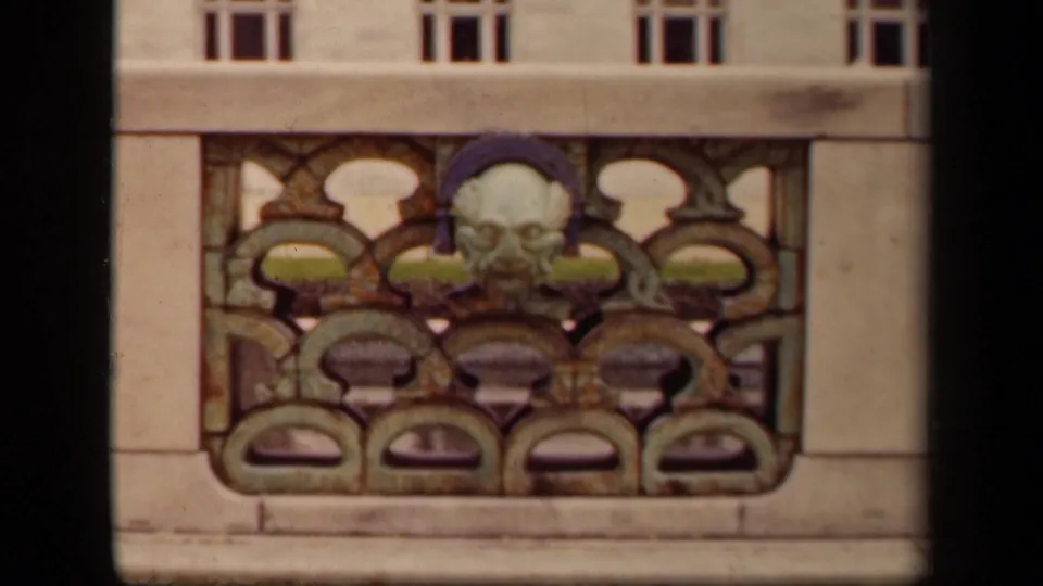 1943 Washington, DC 8mm frame showing a carved face and ornate repeating stonework below building windows.