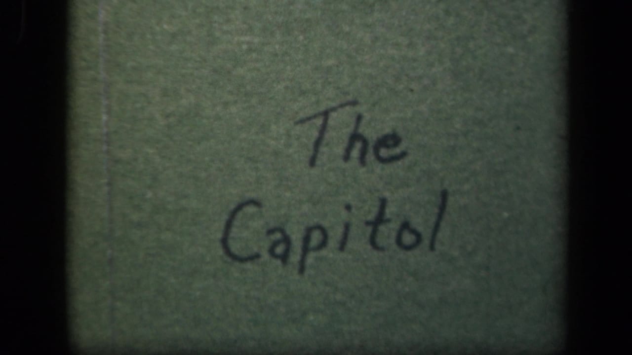 1940s 8mm title card for a Washington, D.C. Capitol view, handwritten on a green background and framed by film edges.