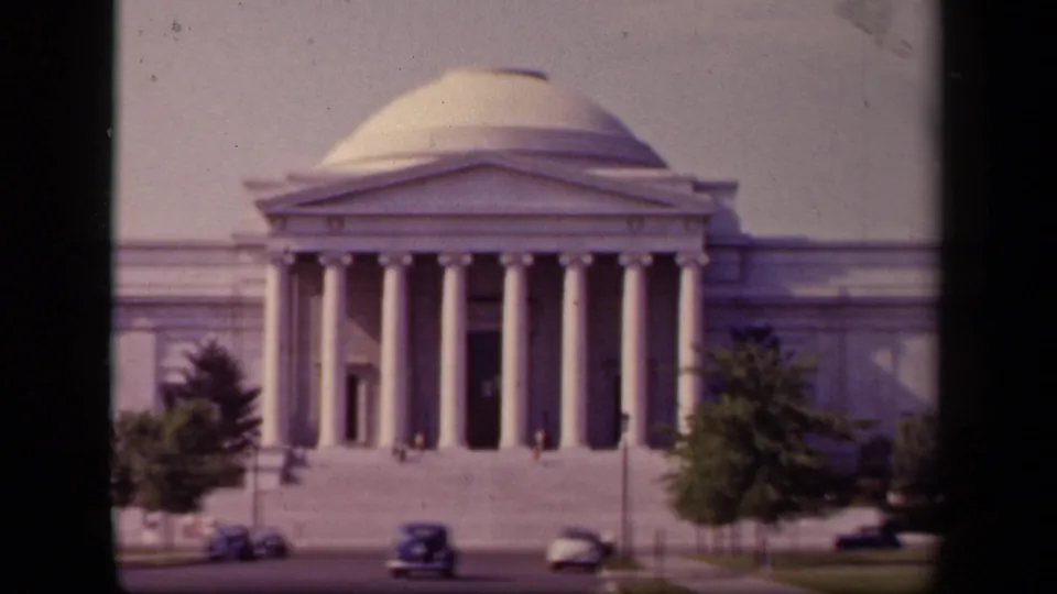 The Jefferson Memorial in Washington, DC appears in soft 8mm color with 1940s cars and distant visitors near the columns.