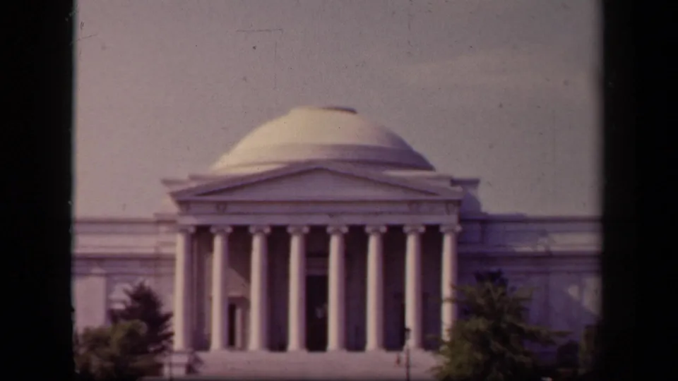 1943 home-movie frame of the Jefferson Memorial in Washington, DC, with its dome and columned portico centered beyond dark framing.