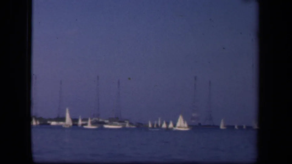 1943 Washington, DC waterfront scene with sailboats and small yachts on open water, seen in soft 8mm color.