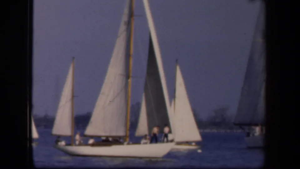 Closer 1943 Washington DC sailing view with a white-hulled boat, several sails, and small people visible aboard.