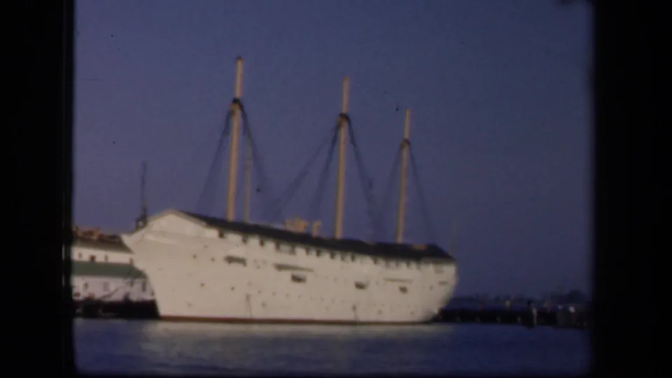 A large white docked ship with tall masts is seen across the water in 1943 Washington, DC home-movie footage.