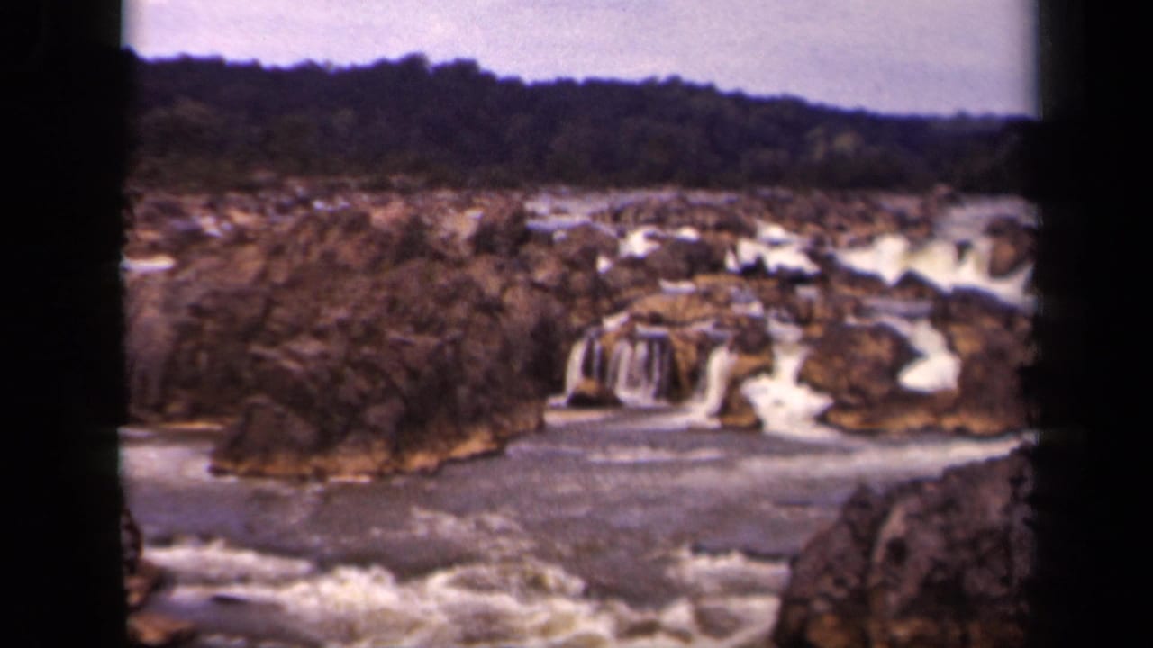 Wide 8mm view of a rocky waterfall and rapids in the Washington, DC metadata setting, with trees along the far bank and soft film edges.