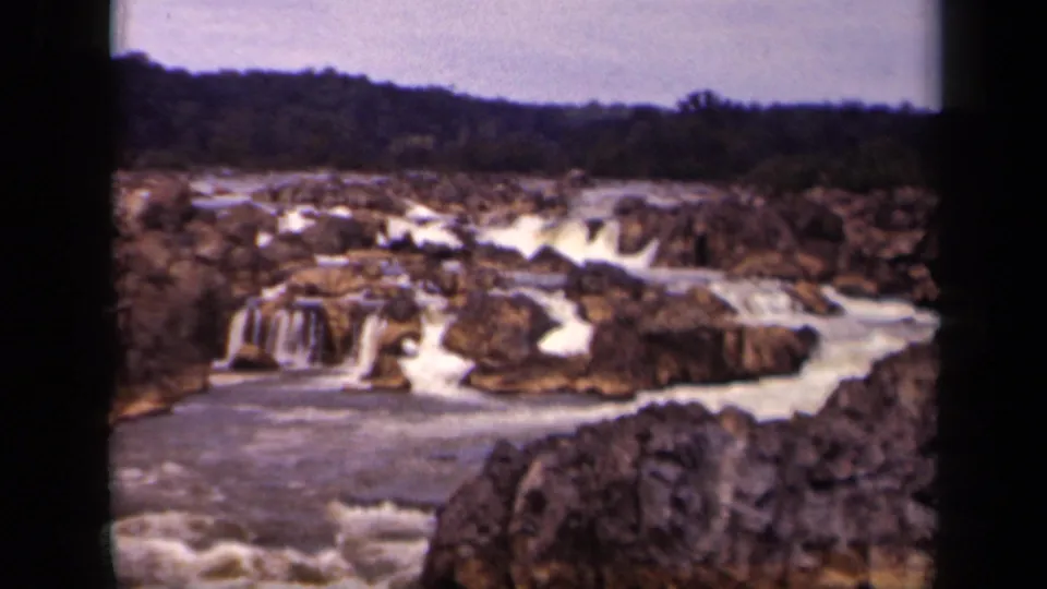 Mid-pan 8mm view of rocky cascades and foaming water in Washington, DC, based on supplied clip metadata.