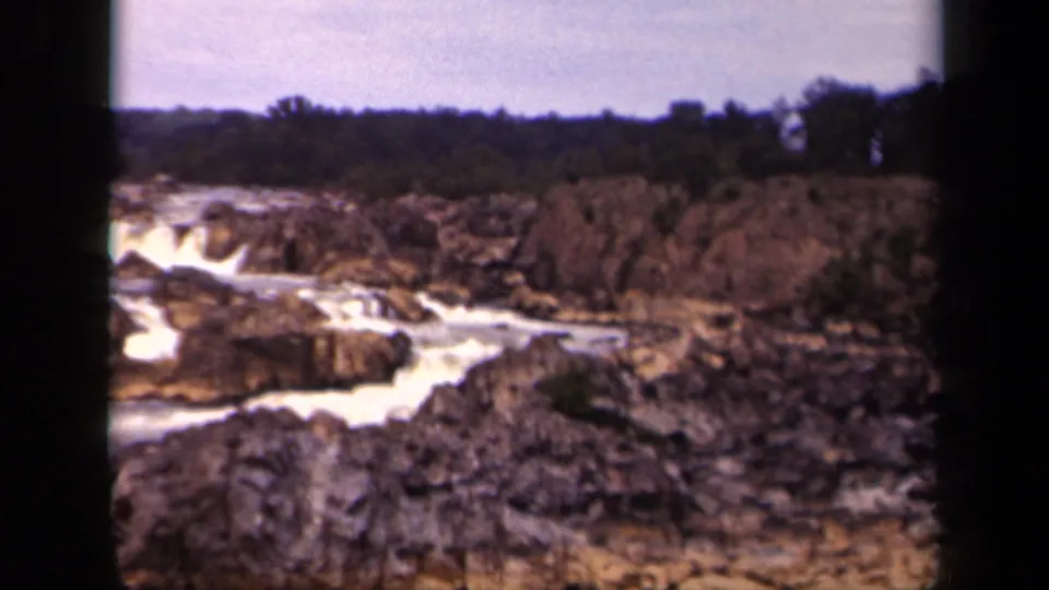 Vintage 8mm frame from Washington, DC in 1943 showing whitewater winding through rugged rocks and a wooded far bank.