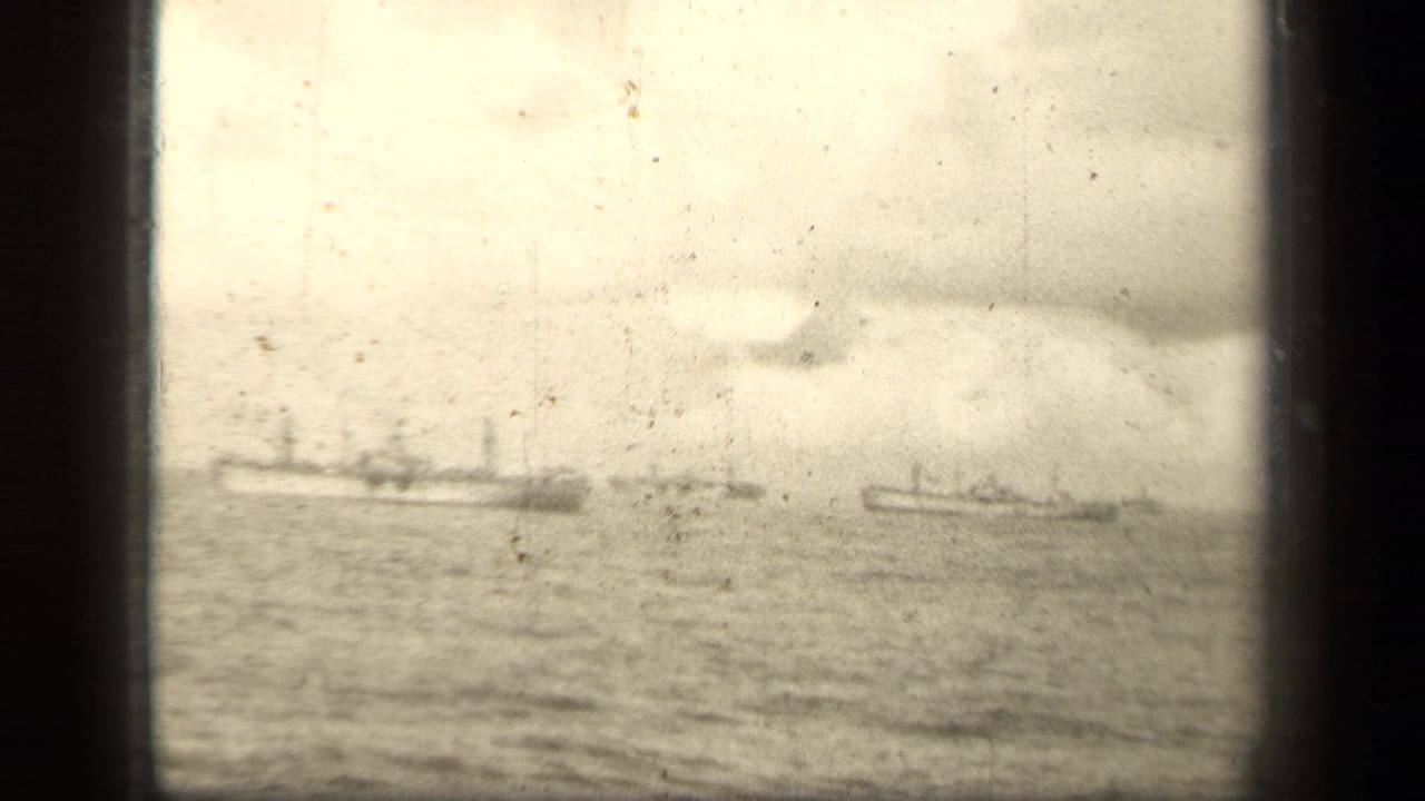 Distant naval vessels on open water near Leyte Gulf, filmed in soft monochrome 8mm under heavy clouds.