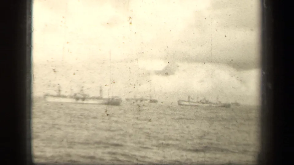 Distant naval vessels on open water near Leyte Gulf, filmed in soft monochrome 8mm under heavy clouds.