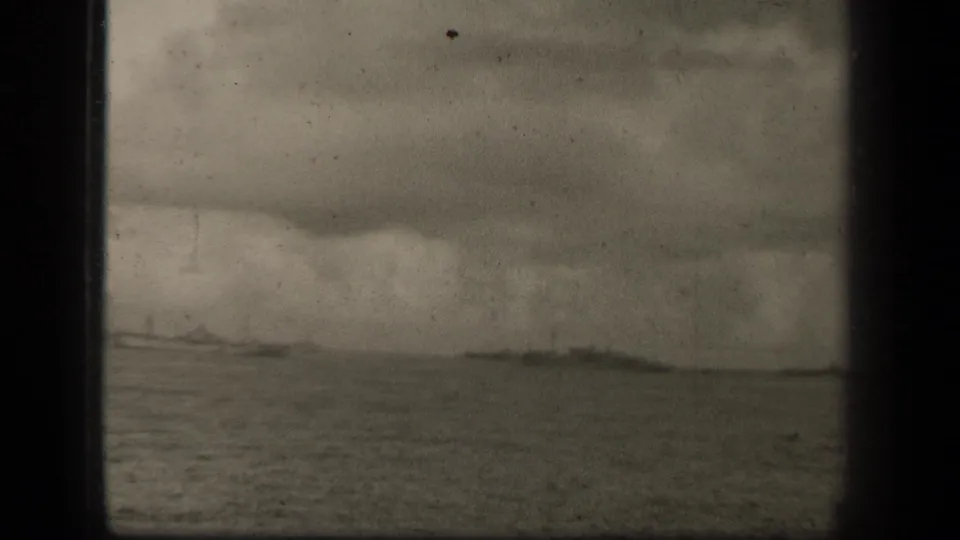 A distant naval fleet appears along the Leyte Gulf horizon in a soft, grainy 1944 8mm home-movie frame.