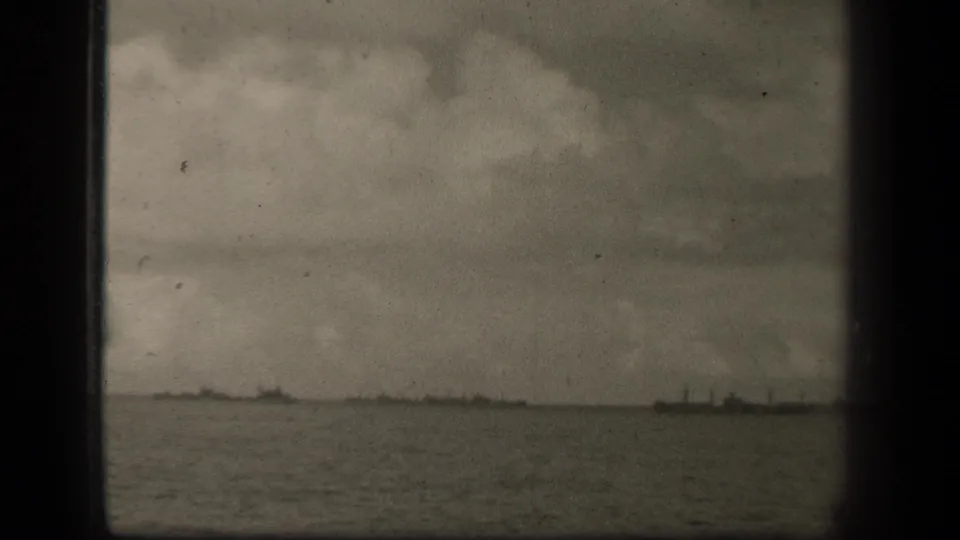 A wide 1944 Leyte Gulf water view shows distant vessel silhouettes under a heavy sky, softened by grain and film age.
