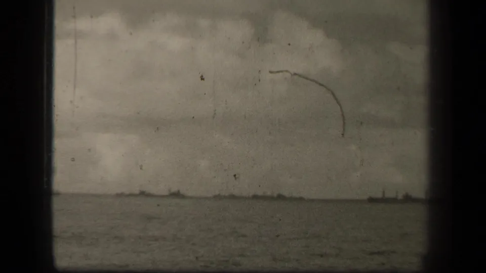1944 Leyte Gulf footage showing a distant military ship on open water under an overcast sky, with visible 8mm gate edges and scratches.