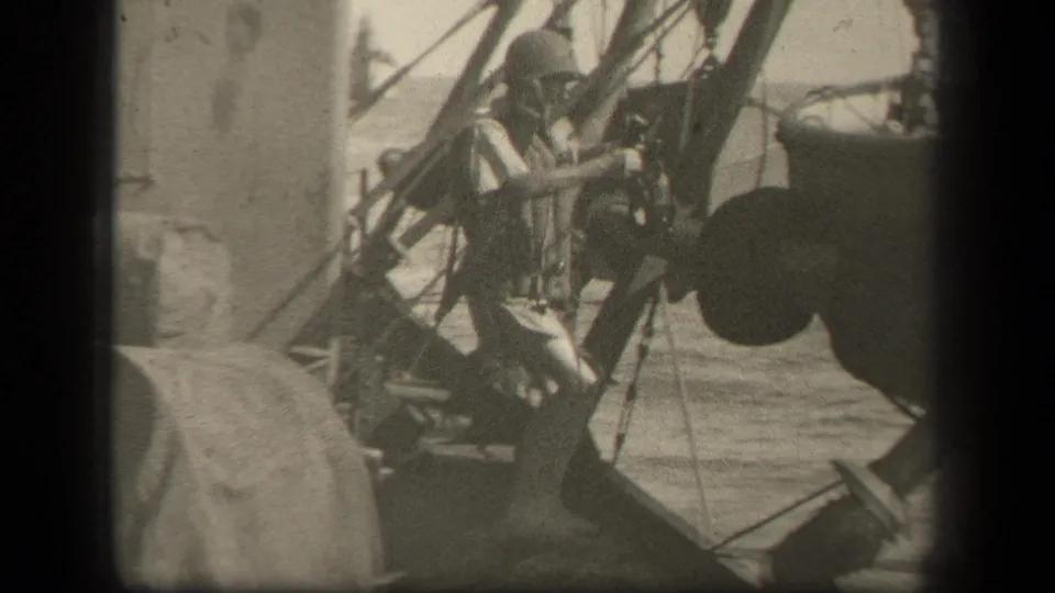 In 1944 Leyte Gulf footage, a helmeted soldier appears beside rigging and a suspended boat on a ship deck.