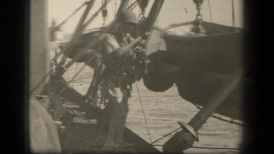 The soldier is partly hidden by ship rigging while moving near the suspended boat in the Leyte Gulf setting.