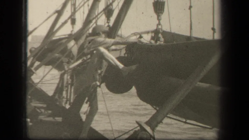 In the supplied 1944 Leyte Gulf clip, a helmeted U.S. serviceman appears beside ship rigging and deck equipment with open water in the background.