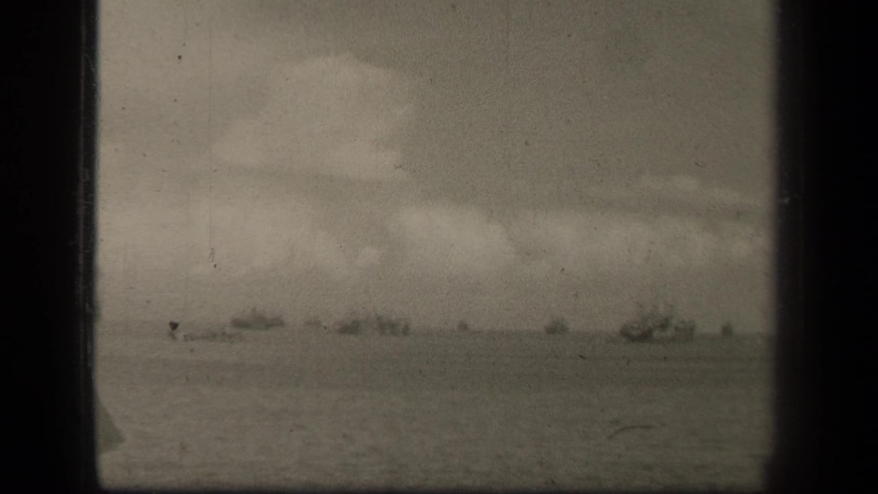 Distant ships on open water beneath a cloudy sky, seen through an 8mm film frame.