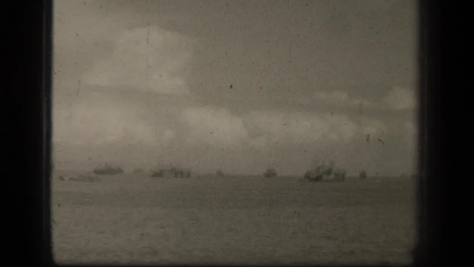 Supported by the clip metadata, this Leyte Gulf frame shows distant wartime vessels spread across a cloudy ocean horizon.