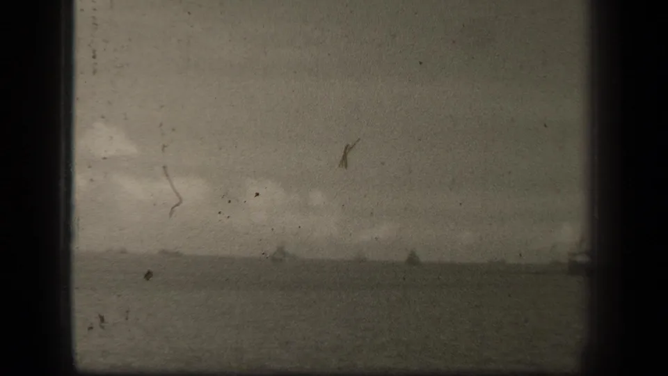 Distant 1944 Leyte Gulf naval silhouettes appear along the waterline in grainy, damaged 8mm footage.
