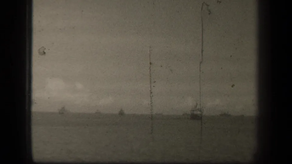 1944 Leyte Gulf horizon view with faint naval vessels, vertical film scratches and heavy 8mm grain.