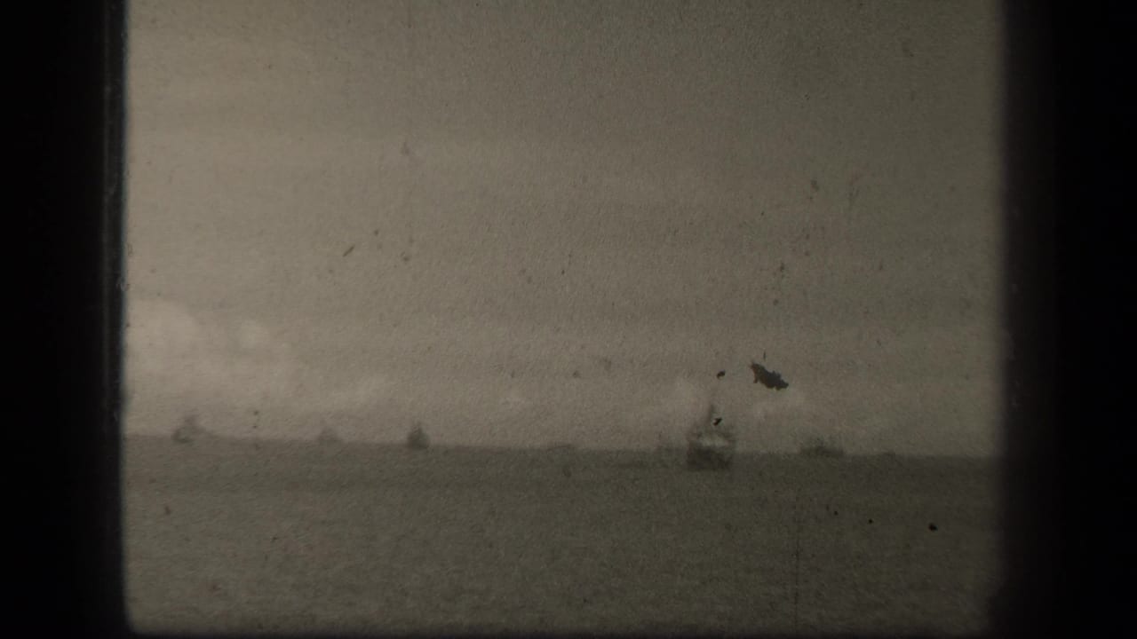Hazy sea horizon with distant vessels and dark film gate edges.