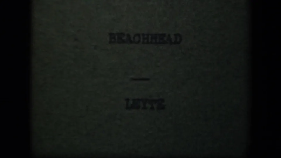 Dim 8mm title card reading “BEACHHEAD — LEYTE,” confirming the supplied Leyte Gulf wartime setting.