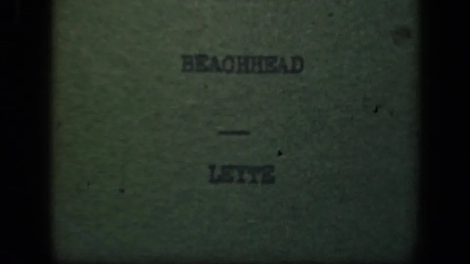 Repeated Leyte beachhead title card on worn 8mm film, with soft lettering, scratches, and uneven exposure.