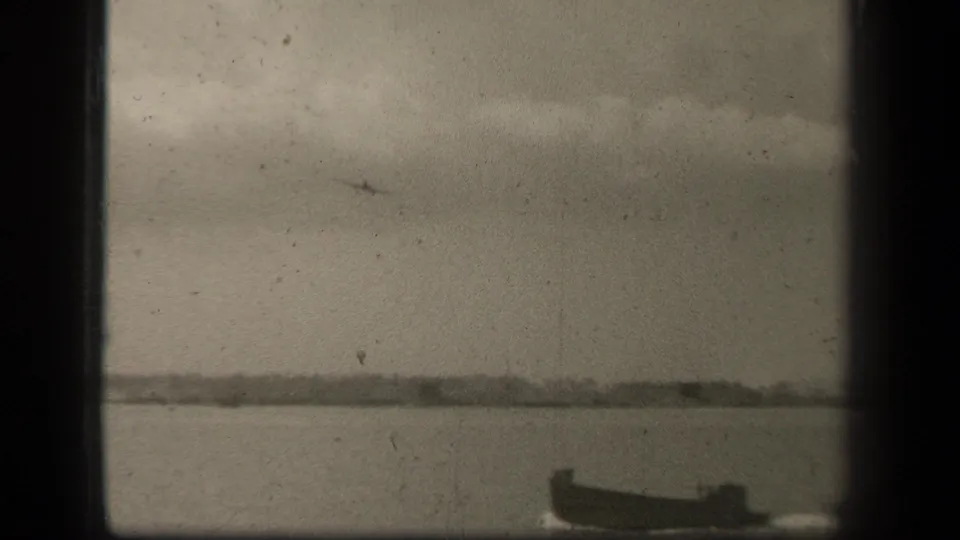 Leyte Gulf view with a small boat near the lower right and a distant aircraft silhouette crossing an overcast sky.