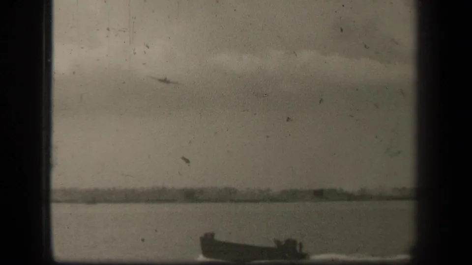 Wartime Leyte Gulf footage shows a small boat along the lower edge and a faint aircraft silhouette in the cloudy sky.