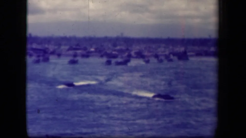 A wide Leyte Gulf view shows open water, small vessels or wakes, and a distant shoreline under a cloudy sky.