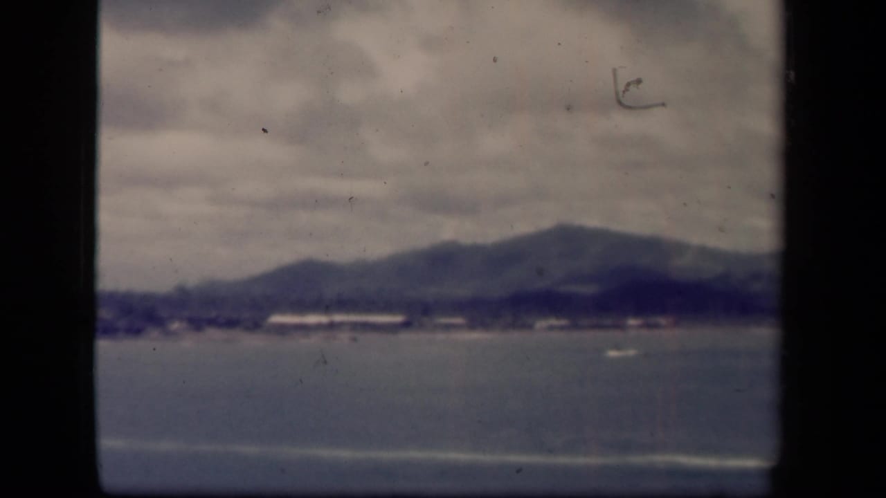 Leyte Gulf, Philippines 1944 home-movie frame showing water, distant shoreline, and low mountains through soft 8mm exposure.