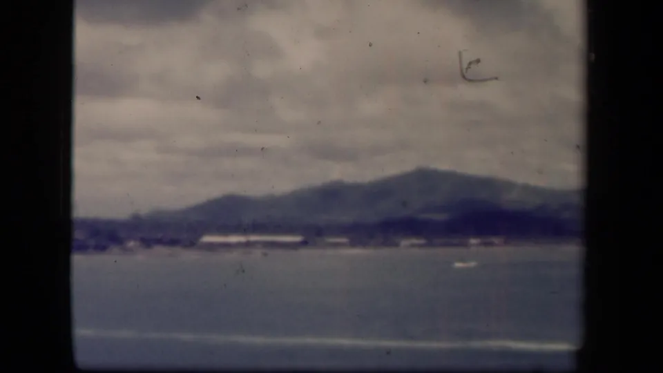 Leyte Gulf, Philippines 1944 home-movie frame showing water, distant shoreline, and low mountains through soft 8mm exposure.