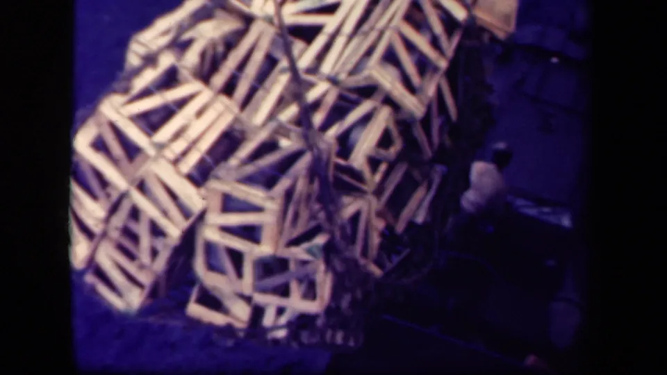 Wooden cargo crates stacked on deck in 8mm footage identified as 1944 Leyte Gulf, with dark borders and purple color cast.