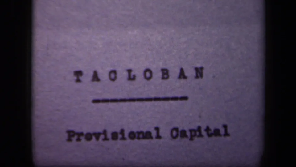 1944 8mm frame showing Tacloban typed above an underline and Provisional Capital below, with visible grain and frame edge.