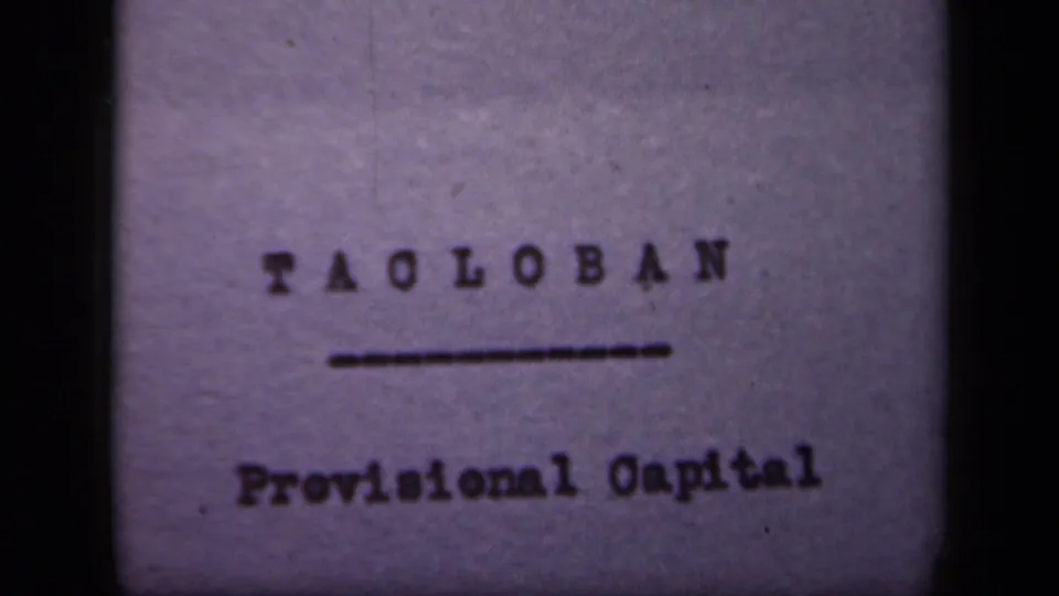 1944 Leyte Gulf Philippines 8mm frame holding on the Tacloban Provisional Capital title card with soft focus and purple tint.