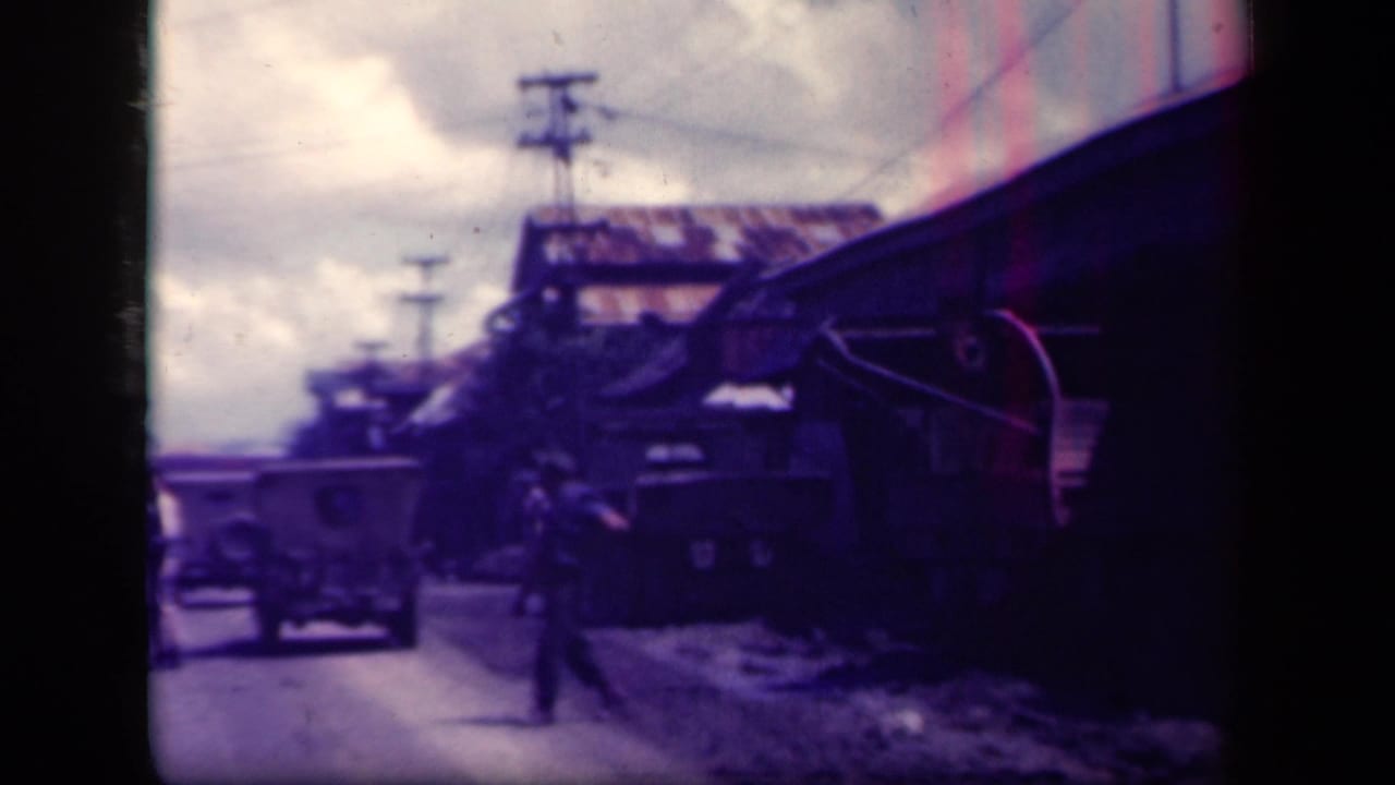 A car and a pedestrian appear on a dirt road in Leyte Gulf, Philippines, with utility poles and roadside buildings visible.
