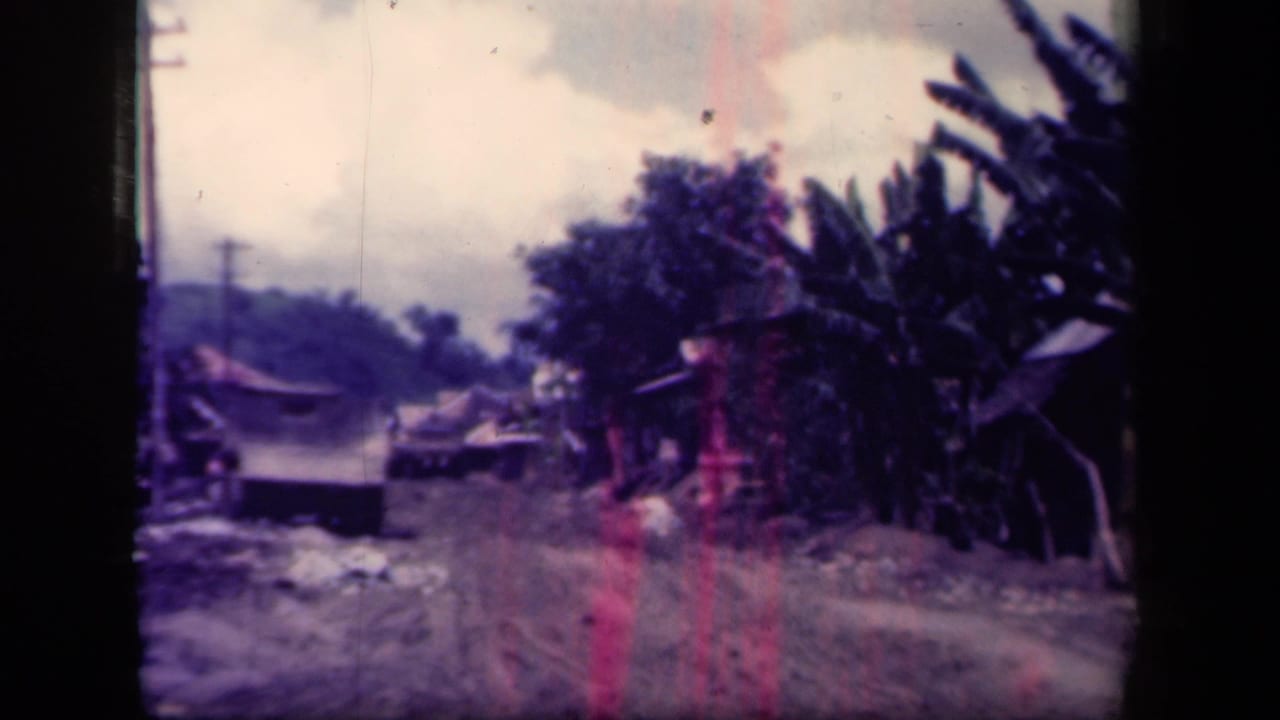 Leyte Gulf village road scene with dense tropical plants, a rough dirt track, and a distant vehicle shape.