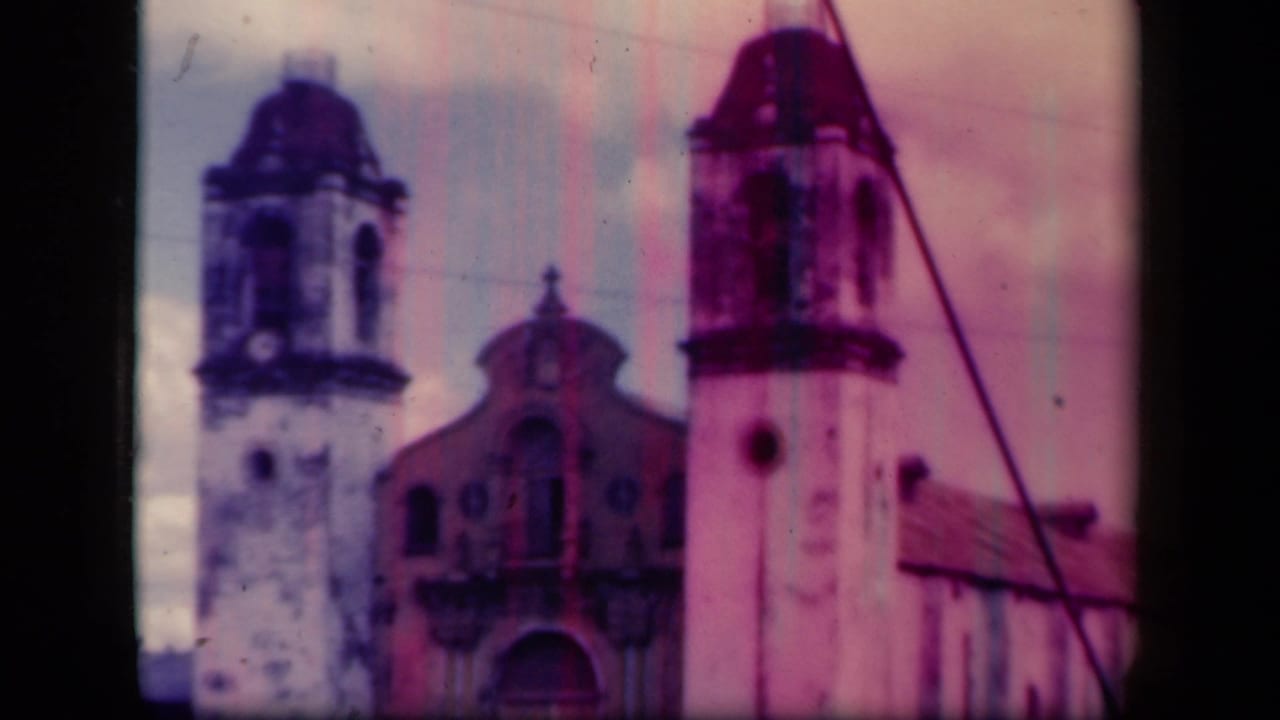 Twin-tower church facade seen through faded 8mm color and dark film borders.