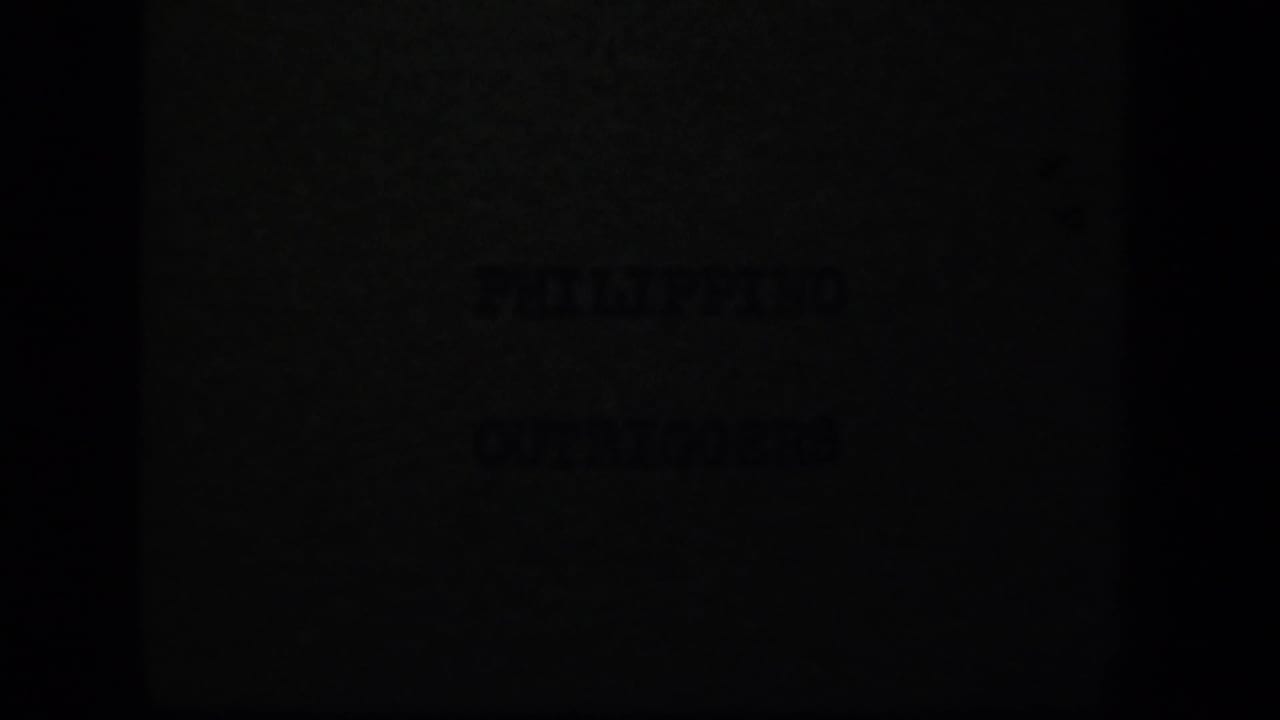 Dark 8mm frame with faint title-card lettering, likely part of the “PHILIPPINO OUTRIGGERS” card sequence.