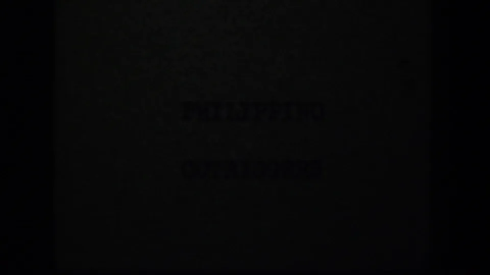 Dark 8mm frame with faint title-card lettering, likely part of the “PHILIPPINO OUTRIGGERS” card sequence.