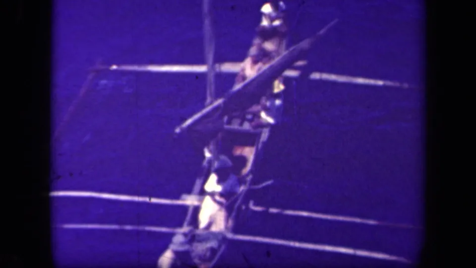 Several men appear aboard a Filipino outrigger canoe on the waters of Leyte Gulf, seen in purple-blue shifted 8mm footage.
