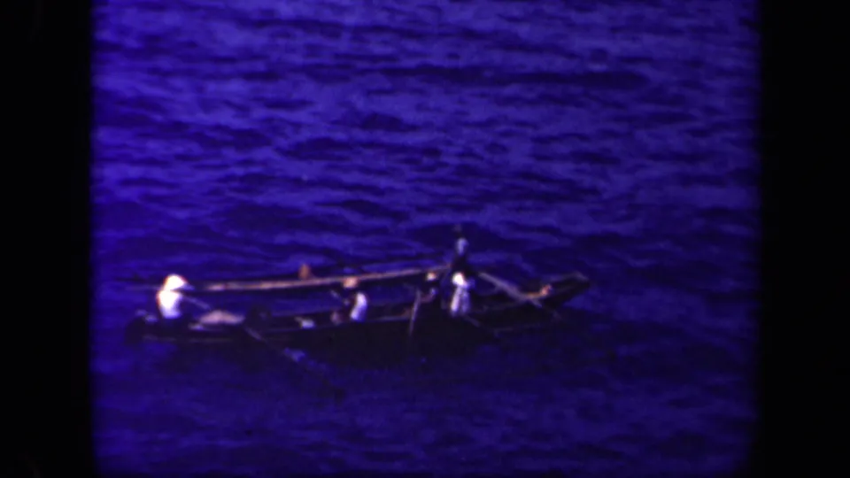 A distant outrigger canoe carries several people across Leyte Gulf, with paddles or spars extending over the water.