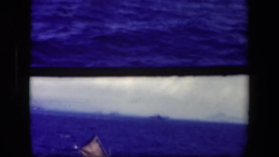 1944 Leyte Gulf 8mm frame, partly cropped in the contact sheet, showing a small sailboat below a pale sky and dark horizon.