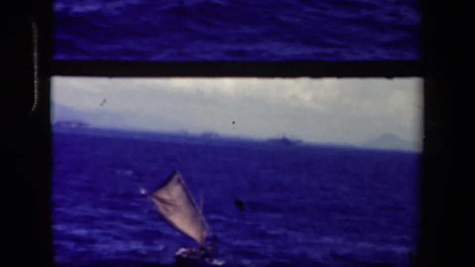 1944 Leyte Gulf 8mm frame showing a distant small sailboat under a cloudy sky, with heavy contact-sheet borders visible.