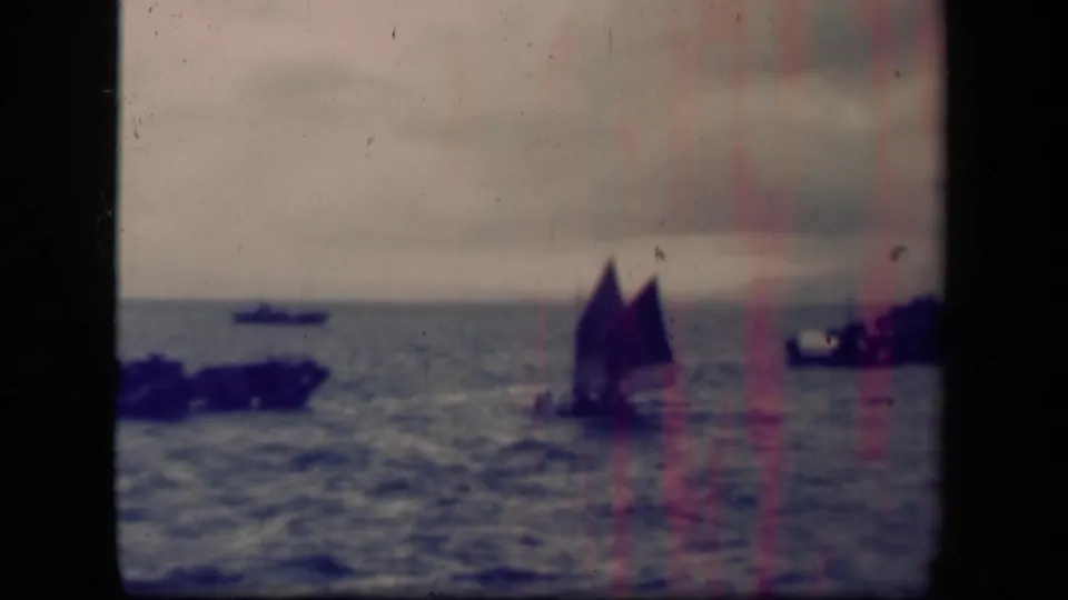 Wider 1944 Leyte Gulf view with the sailboat farther away, nearby boats at left and right, and a hazy horizon.