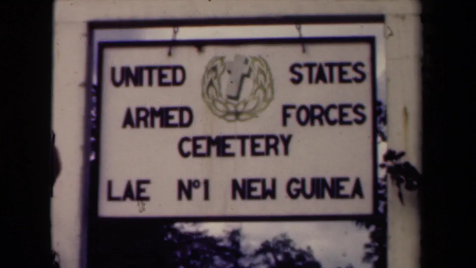 The sign remains centered, identifying the United States Armed Forces Cemetery at Lae No. 1 New Guinea.