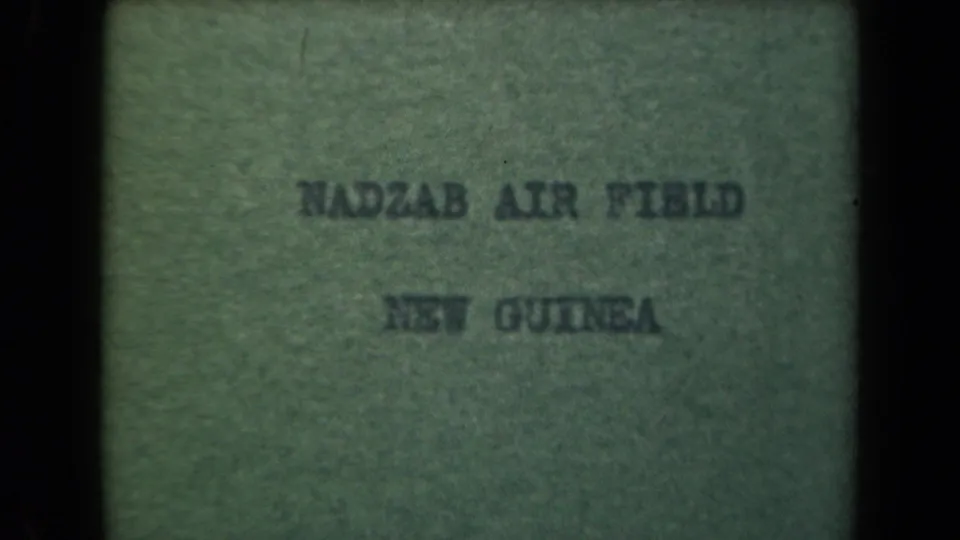 8mm title card for the 1944 Papua New Guinea sequence, reading Nadzab Air Field New Guinea on a greenish textured background.