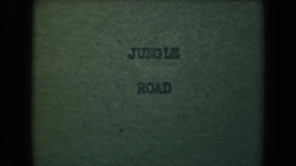 Final 8mm title-card frame with JUNGLE ROAD centered on a green background and visible film borders.