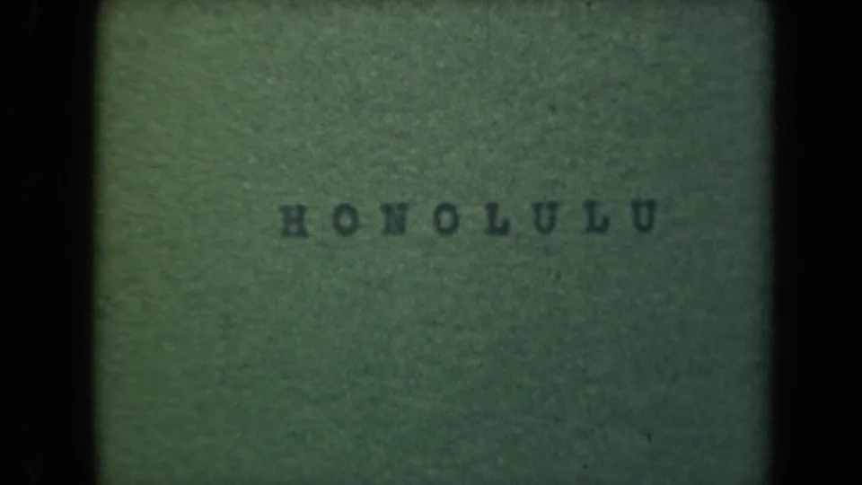 1944 Hawaii 8mm frame showing a green title card with Honolulu stamped in uppercase letters across the center.