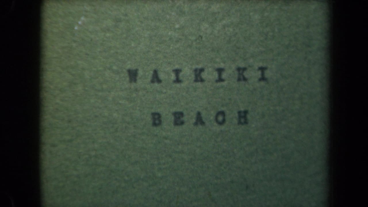 1940s 8mm Hawaii home-movie title card reading Waikiki Beach on a green background with dark frame borders.