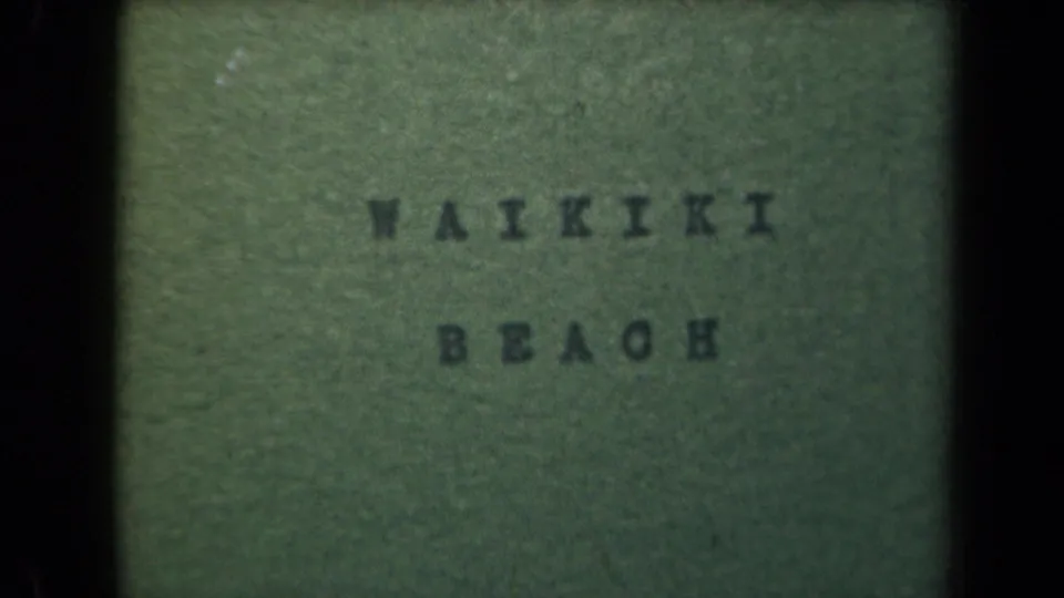 1940s 8mm Hawaii home-movie title card reading Waikiki Beach on a green background with dark frame borders.