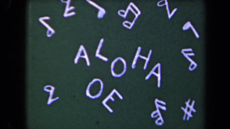 Handmade ALOHA card on dark green background with white lettering and scattered musical-note shapes, from the 1944 Kauai home movie.
